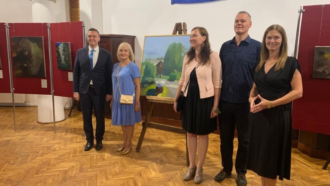 cilvēku kopbilde pie gleznas