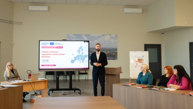 notiek sanāksme, cilveki sēž pie galdiem