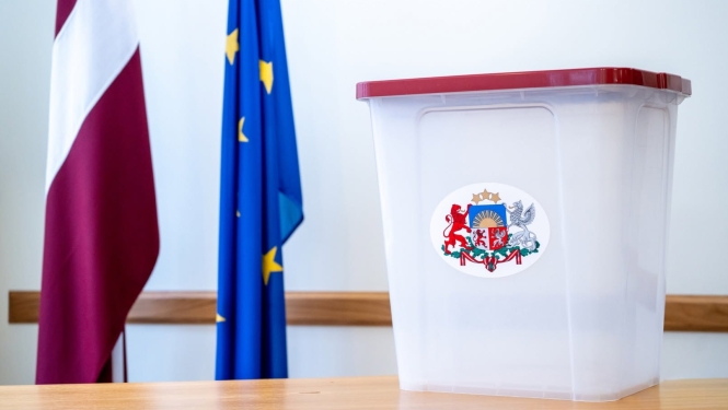 vēlēšanu urna un Latvijas un Eiropas savienības karogs