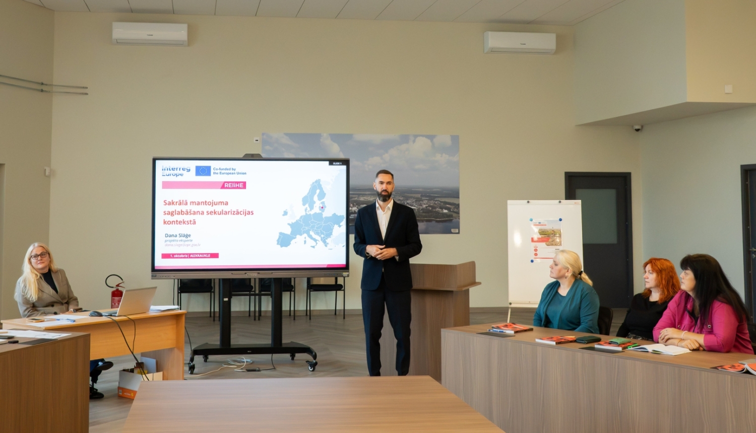 notiek sanāksme, cilveki sēž pie galdiem