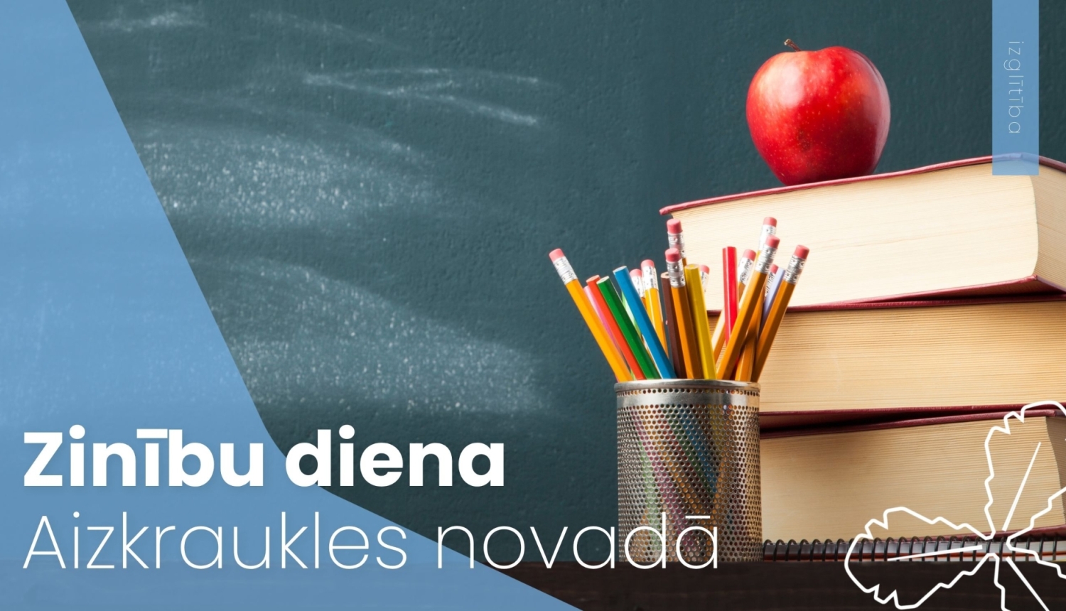 uz grāmatām stāv sarkans ābols, blakus zīmuļi trauciņā