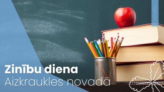 uz grāmatām stāv sarkans ābols, blakus zīmuļi trauciņā