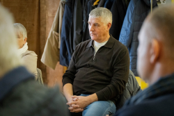 vīrietis klausās prezentāciju