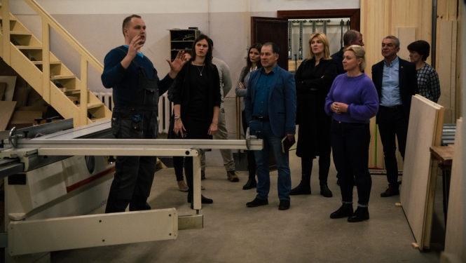 skolotājs stāsta uzņēmejiem par mācībām