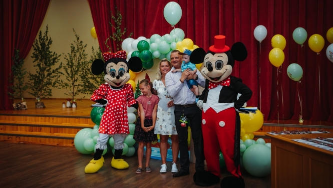 Ģimenes foto ar Mikijpelēm un baloniem.