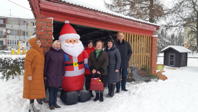 izglītības pāārvaldes darbinieki un domes priekšsēdētajs Skrīveros pie Ziemassvētku vecīša figūras