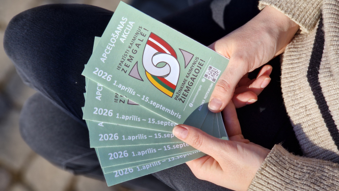 cilvēks tur rokās tūrisma bukletiņus