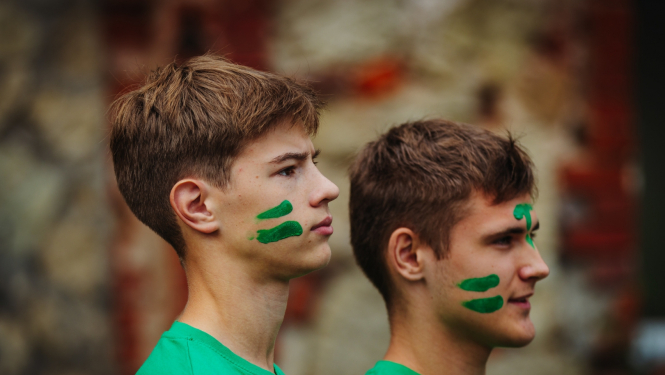 jaunieši zaļos kreklos un sakrāsojušies