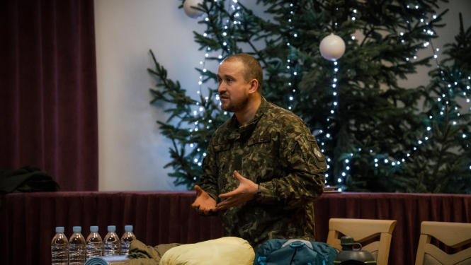 kaprālis iepazīstina klātesošos ar savas ārkārtas gadījumu somas saturu