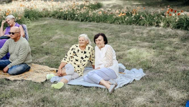 sievietes sēž uz pleda parkā