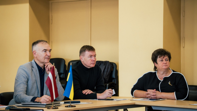 Cilvēki sēž pie galda