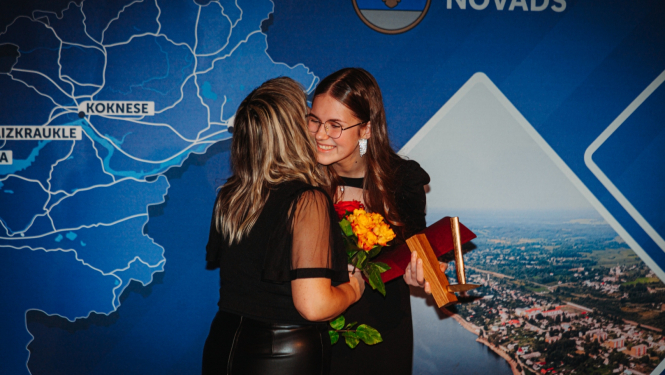 Divi cilvēki apskaujas un smaida