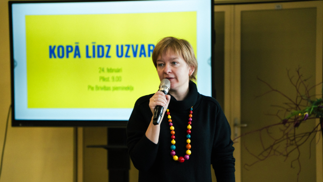 sieviete runā pa mikrofonu