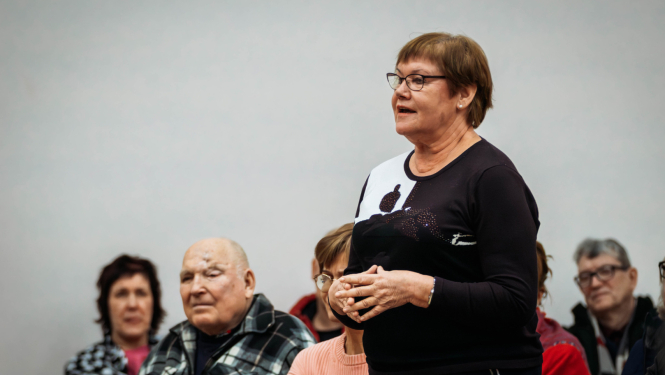 Sieviete piecēlusies kājās runā