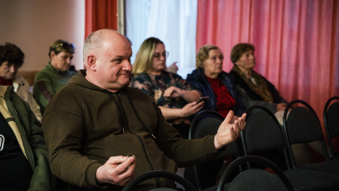 vīrietis rāda ar rokām