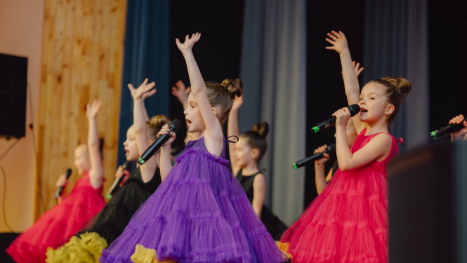 meitenes uzstājās ar dziesmu