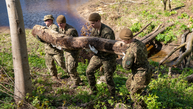 karavīri nes lielu bluķi