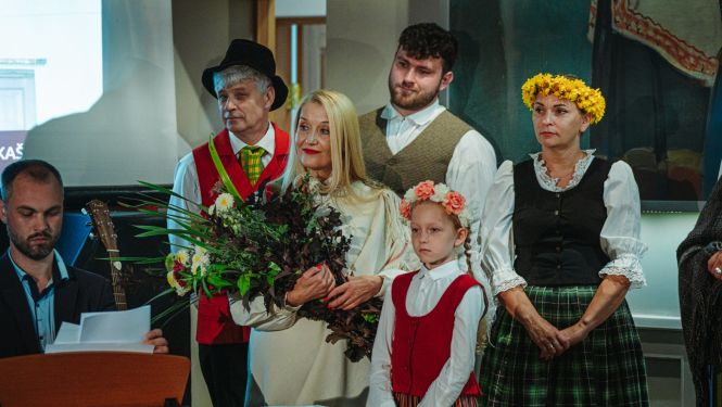 cilvēki stāv pie klavierēm un skatās