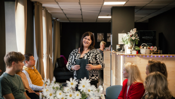 sieviete ar mapi rokās runā 