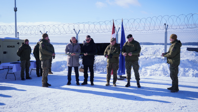 cilvēki griež atklāšanas lentu