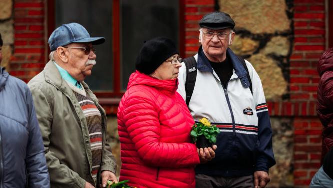 divi vīrieši un sieviete stāv