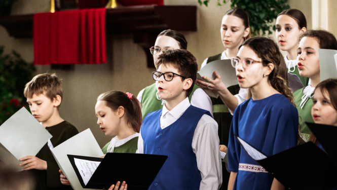 vairāki jaunieši tur rokās mapes un dzied