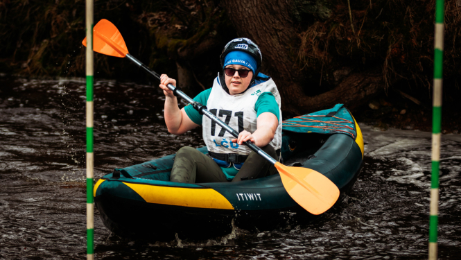 sieviete piedalās sacensībās airēšanā pa upi