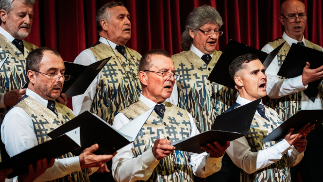 vīrieši tur rokās mapi un dzied