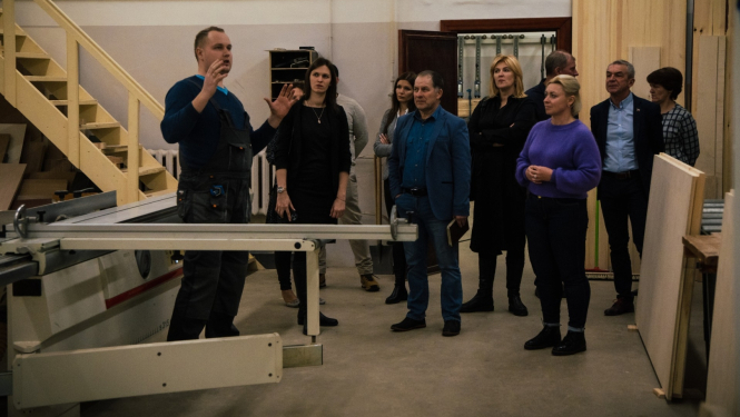 skolotājs stāsta uzņēmejiem par mācībām