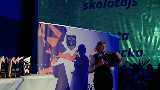 Sieviete tur rokās ziedus un fotografējas