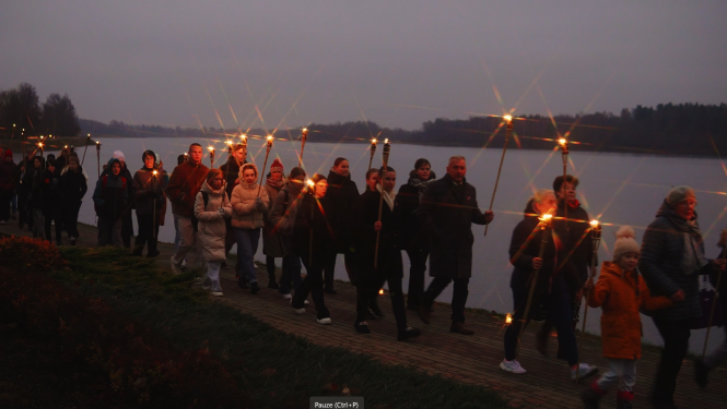 Cilvēki dodas lāpu gājienā