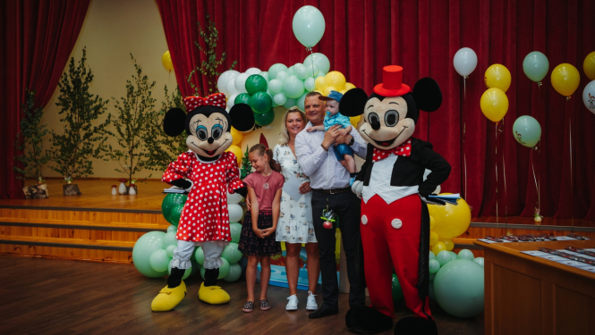 Ģimenes foto ar Mikijpelēm un baloniem.