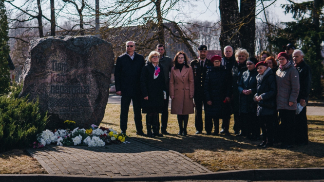 cilēki pulcējas pie piemiņas akmens atceres dienā