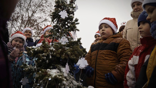 bērni pie zemassvētku eglītes