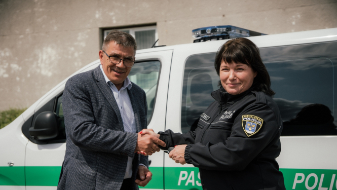 Andris Zālīts un Anita Ozola pie policijas auto