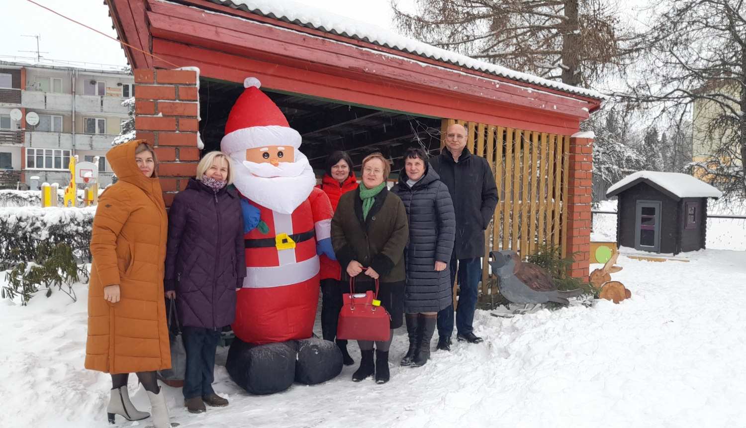 izglītības pāārvaldes darbinieki un domes priekšsēdētajs Skrīveros pie Ziemassvētku vecīša figūras