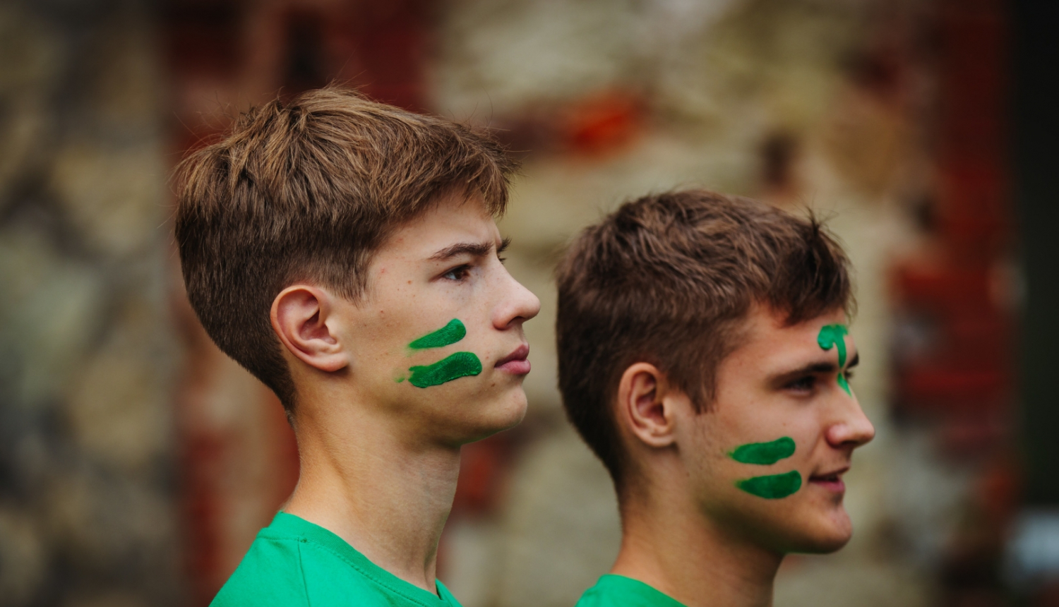 jaunieši zaļos kreklos un sakrāsojušies