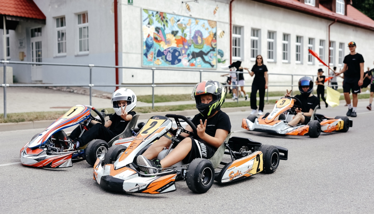 zēni uz kartingiem