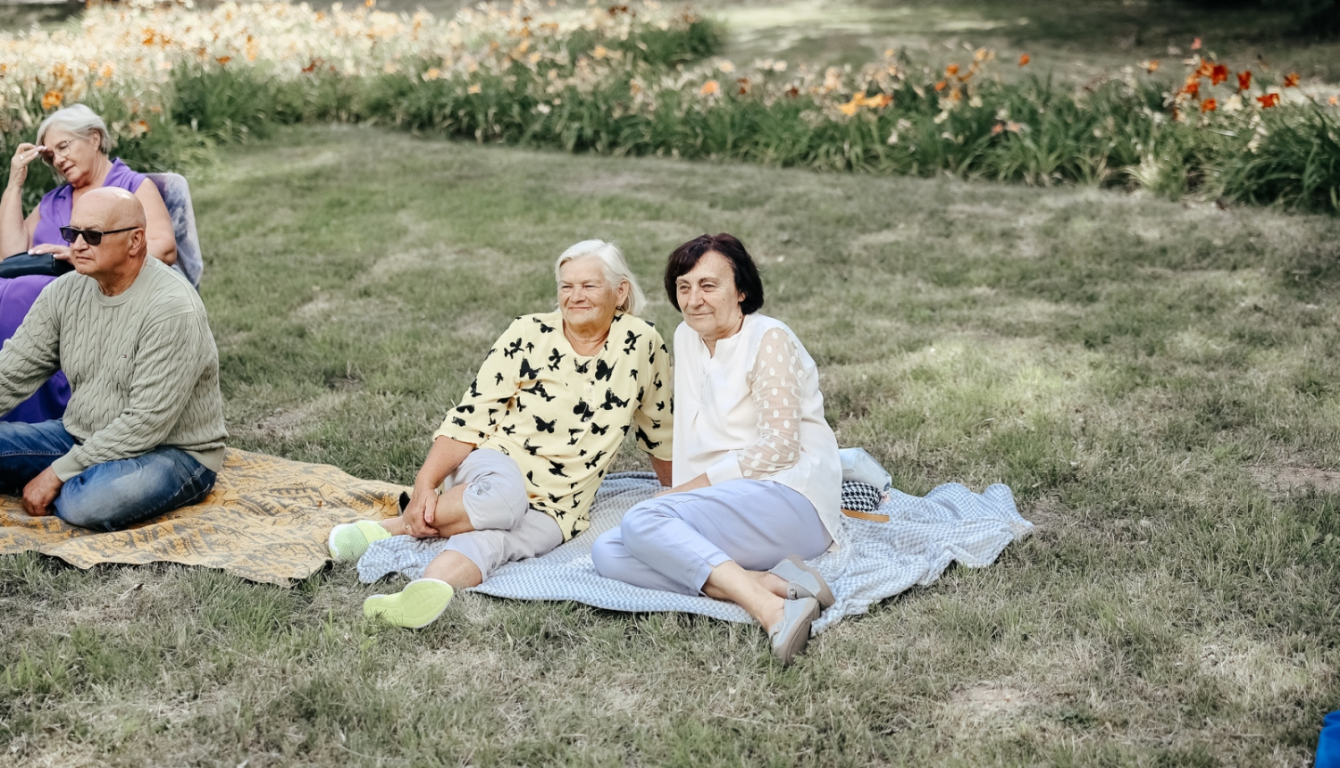 sievietes sēž uz pleda parkā