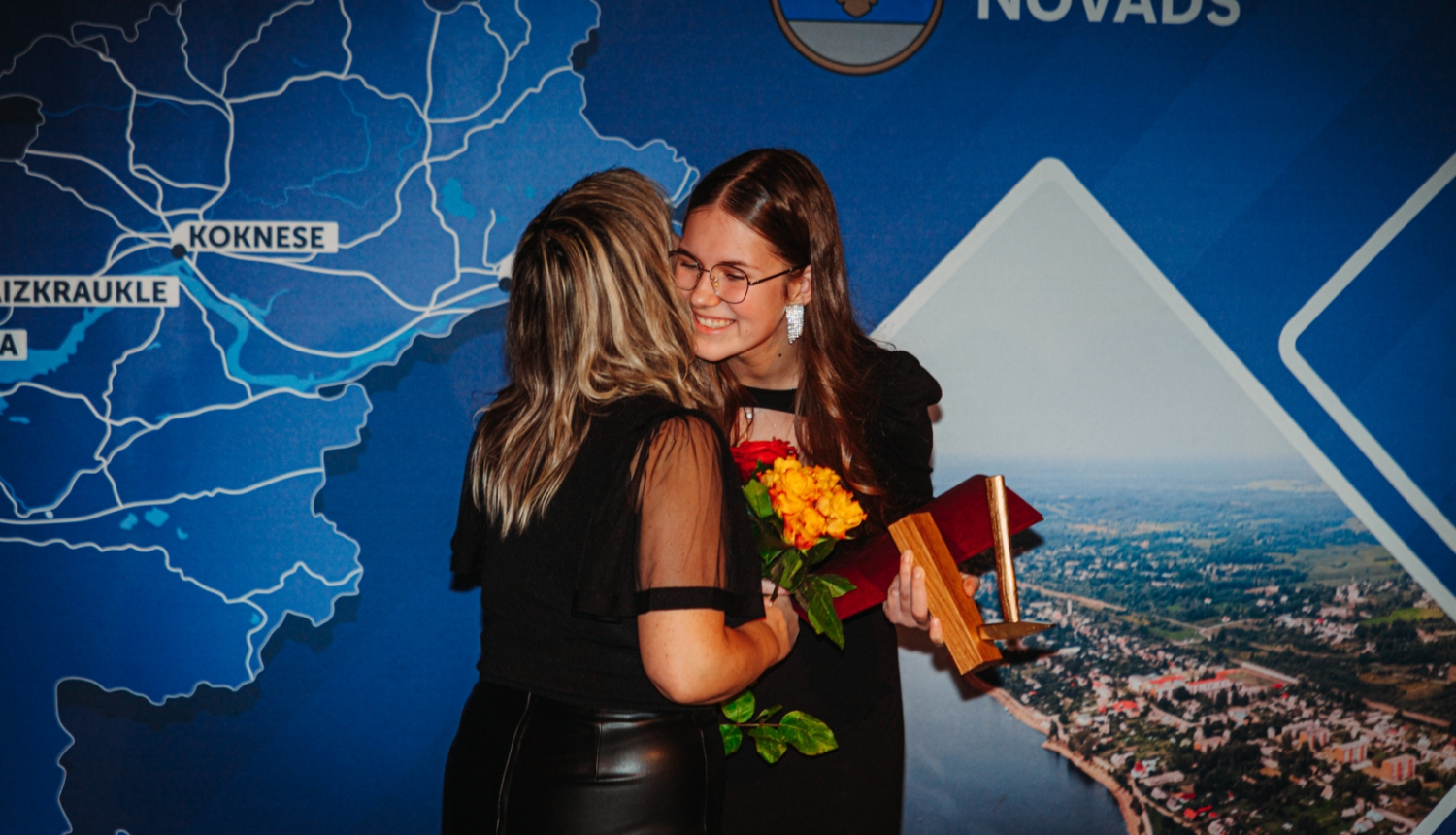 Divi cilvēki apskaujas un smaida