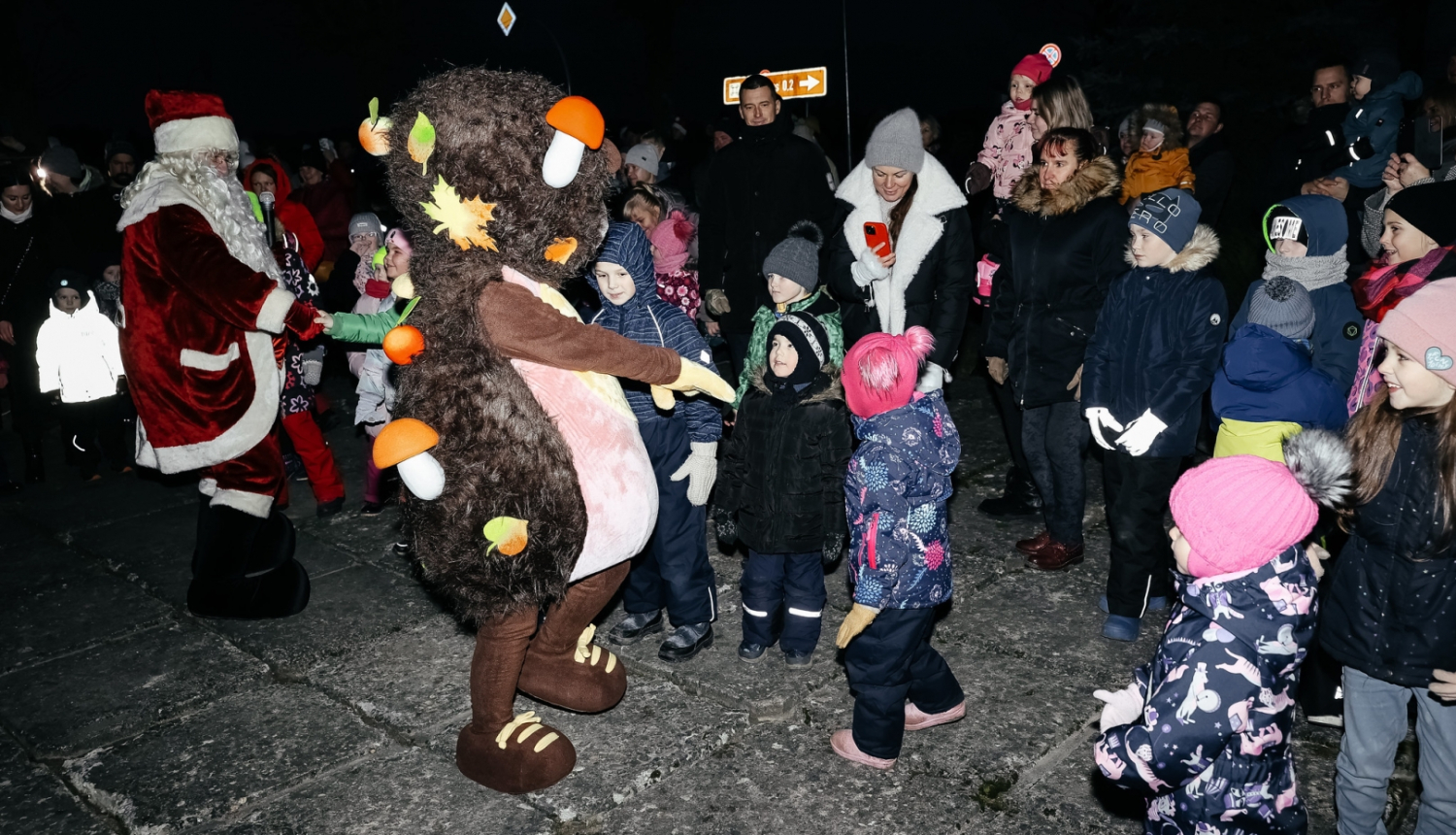 bērni dejo ar svētku tēliem