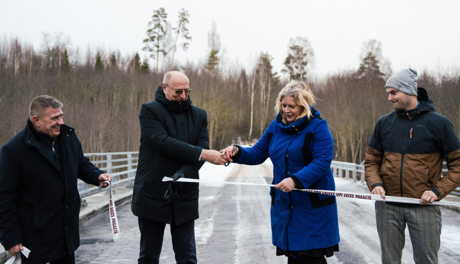 cilvēki griež lentu