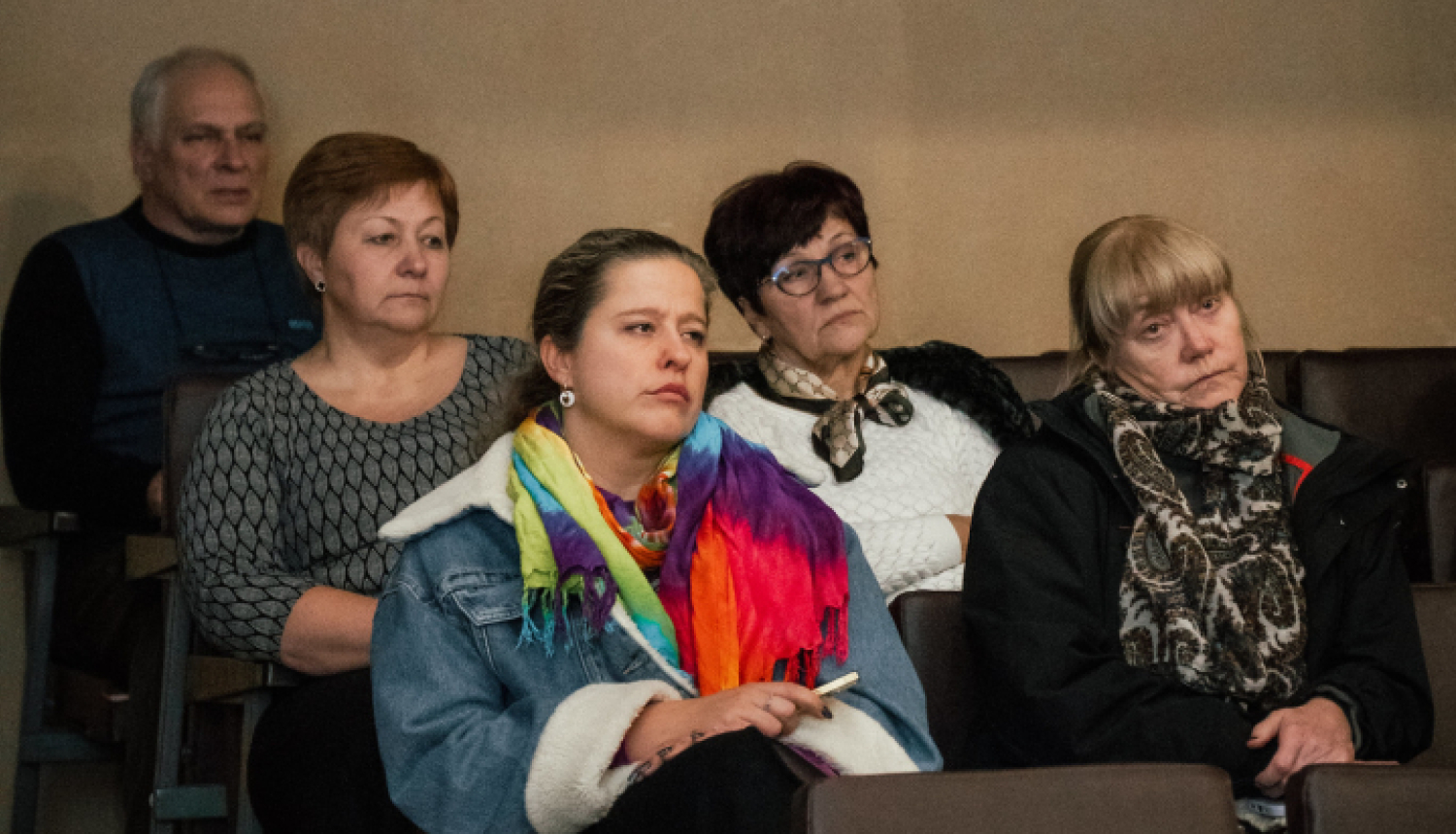 cilvēki sēž un skatās nopietni