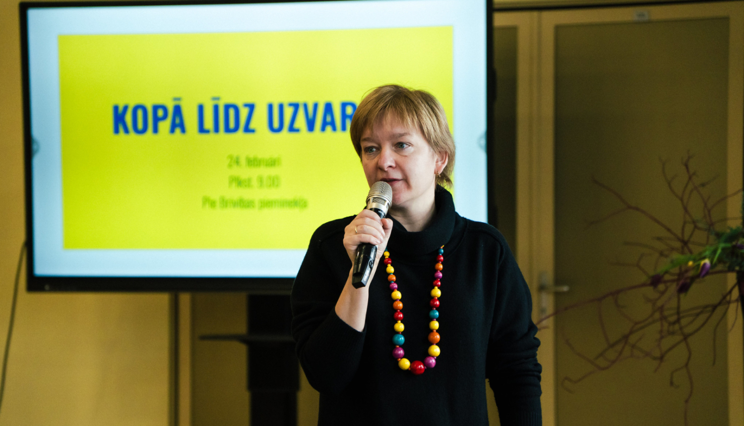 sieviete runā pa mikrofonu