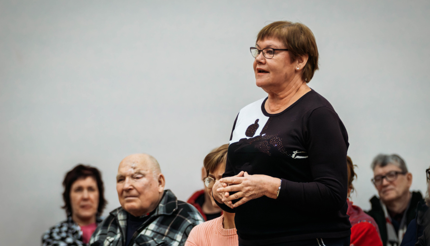 Sieviete piecēlusies kājās runā