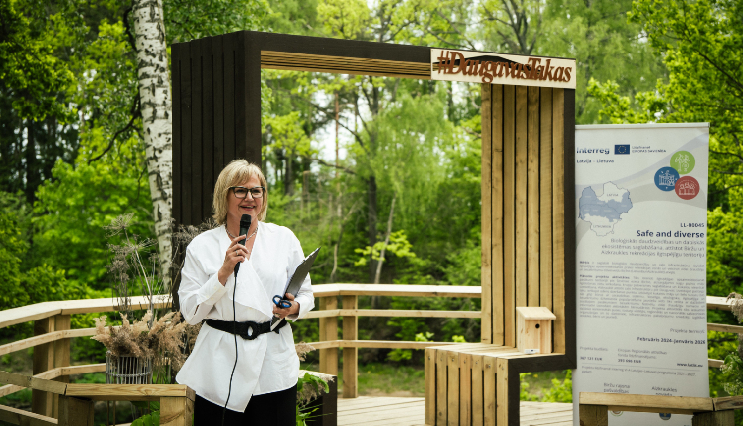 projektu vadītāja runā pa mikrofonu atklāšanas pasākumā