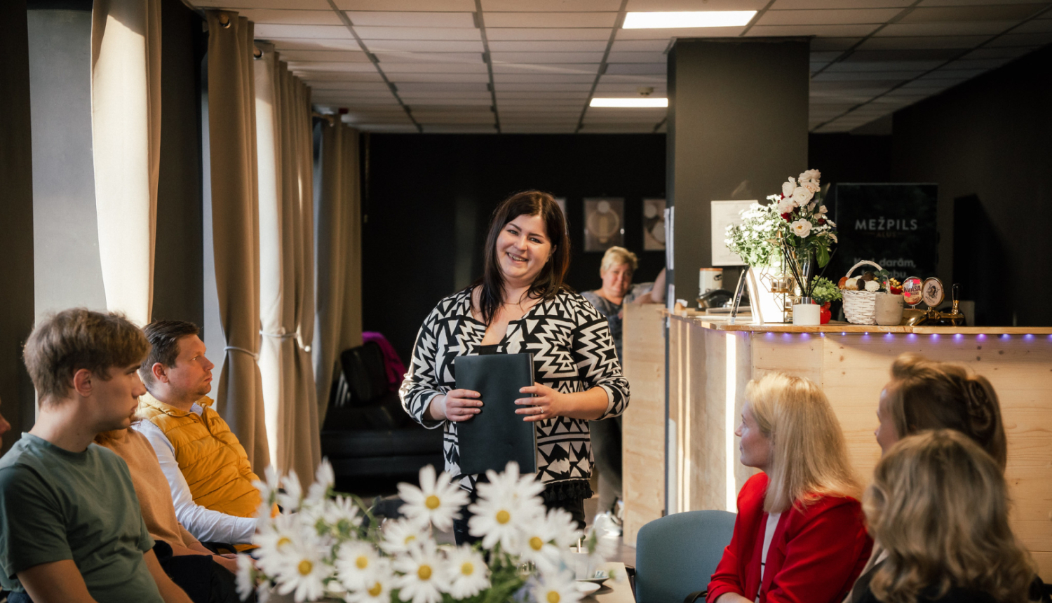 sieviete ar mapi rokās runā 