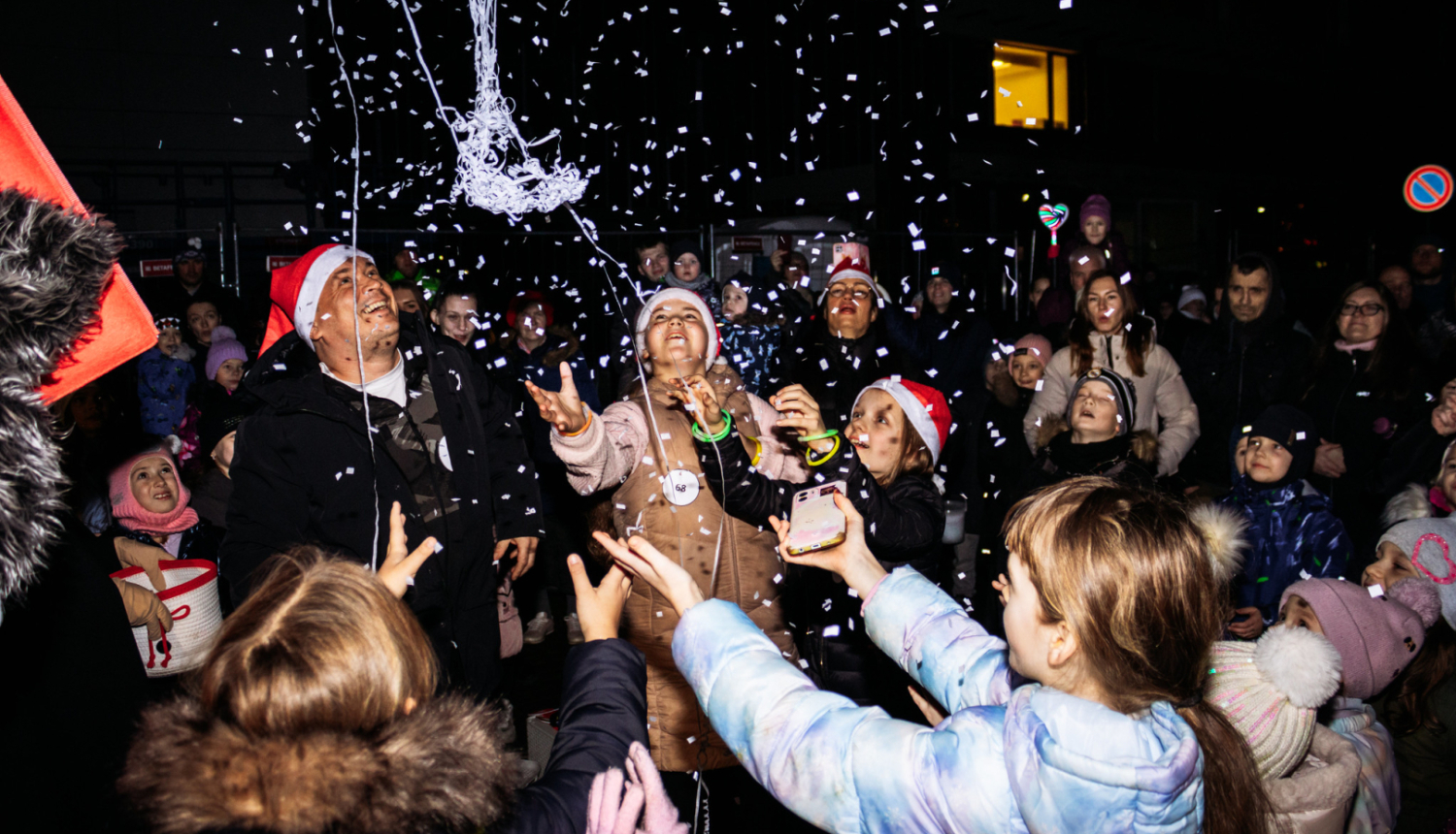 cilvēki priecājās un ķer lapiņas