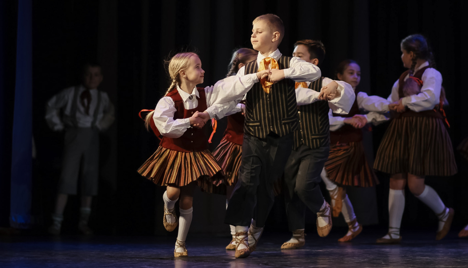 skolēni dejo tautas dejas