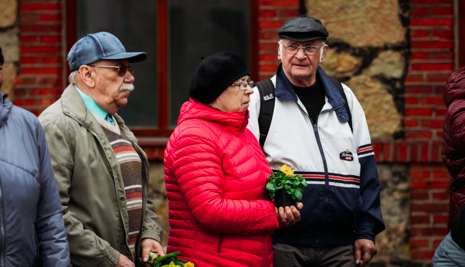divi vīrieši un sieviete stāv